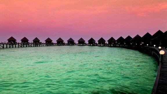 日出时海面上的房屋马尔代夫
