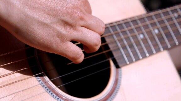 一个年轻女孩的手在弹吉他