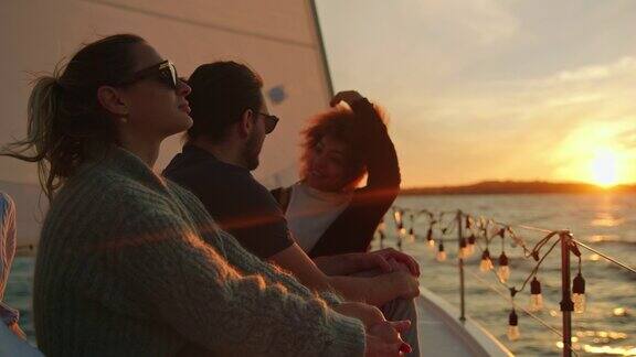 一群朋友在日落时分欣赏风帆