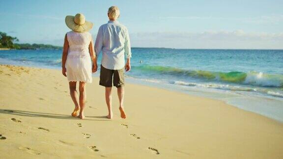 日落时分在海滩上散步的幸福夫妇