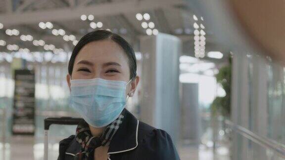 在候机楼等待飞机到达时戴着防护口罩的中国机组人员正在和朋友谈论下一个航班库存视频