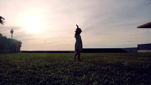女孩在日落的草地上旋转