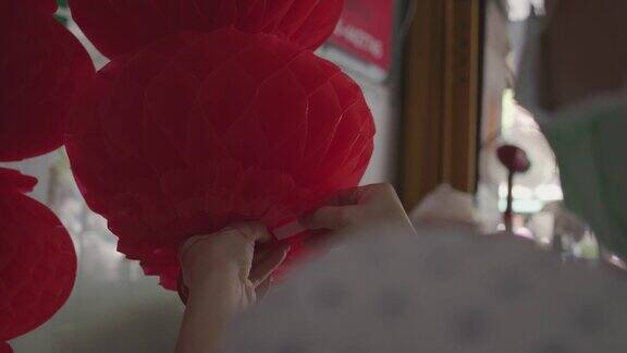 亚洲妇女折叠红纸灯笼庆祝中国新年