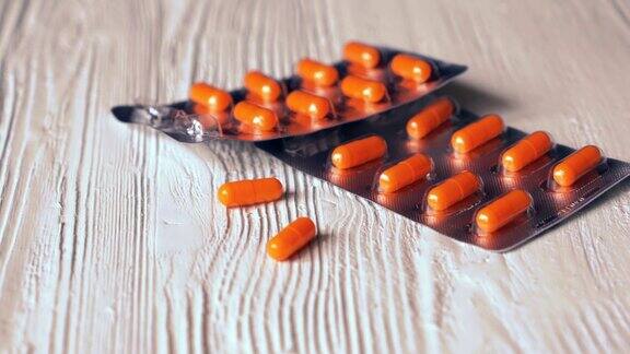 橙色胶囊里的药丸落在白色的桌子上