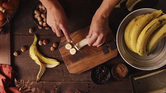 一个女人在厨房切香蕉的手的特写