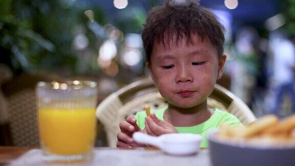 一个男孩在餐厅吃薯条