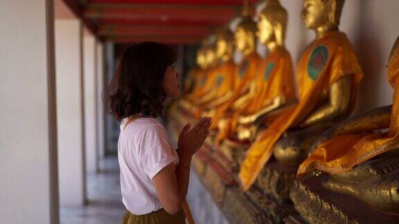 在寺庙里与佛陀一起祈祷的亚洲妇女