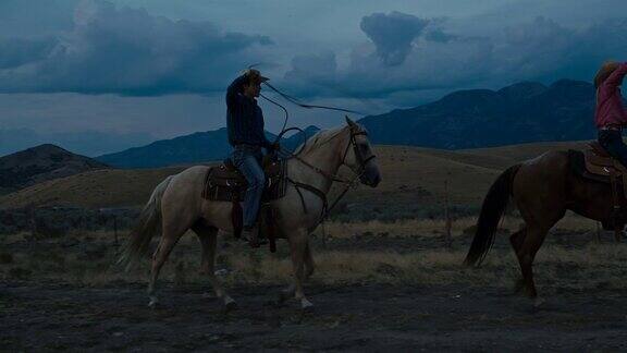 两个年轻人练习套索骑马在晚上在犹他州美国的实时视频