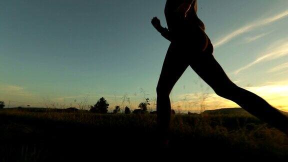 女人的剪影跑步慢动作在日落概念锻炼和健康慢动作