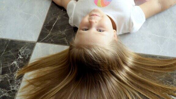 可爱的小女孩躺在地板上