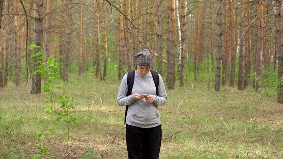 一个背着背包的女人穿过森林前视图