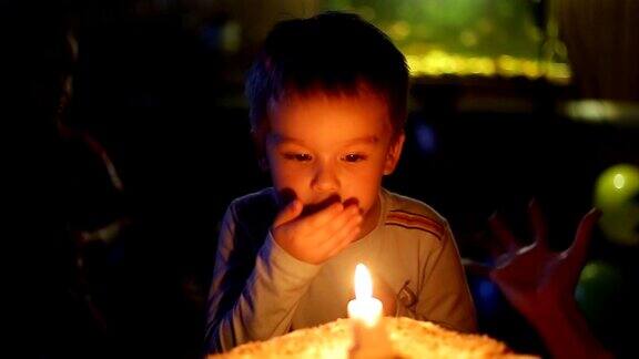 特写小男孩吹灭蛋糕上的蜡烛