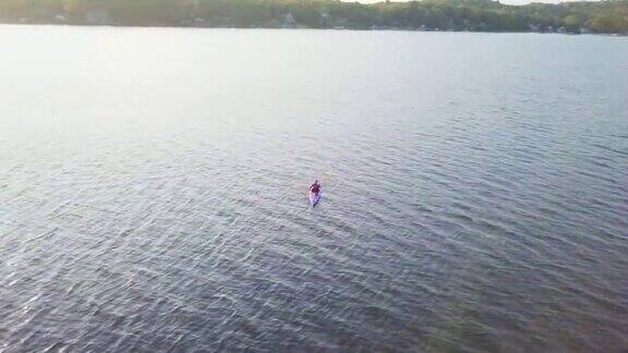 4K航拍视频健康妇女在湖上的日出皮划艇