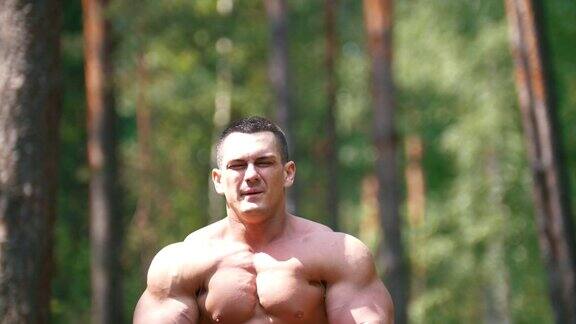 充气男子在夏季森林里锻炼巨大的二头肌