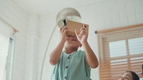 亚洲家庭在家里的客厅里戴着VR头显慢动作
