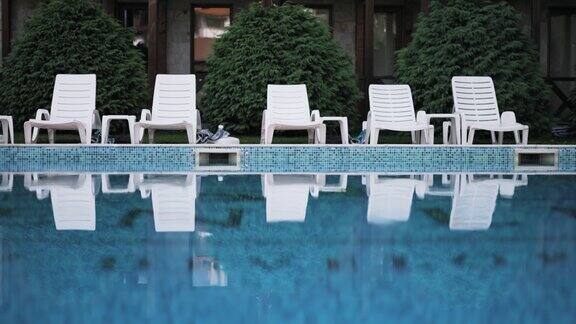 在热带度假水疗中心的豪华游泳池附近的躺椅
