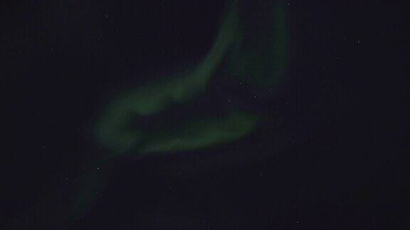 北极光在夜空中群山上空的剪影
