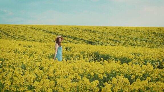 美丽的农妇享受着油菜花的收成美丽的春日黄花的田野