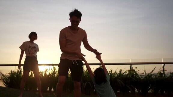 一个亚洲华人家庭和一个孩子在户外欣赏春天的日落美景