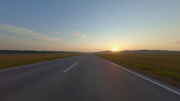 在夏日的夕阳下沿着乡间小路行驶