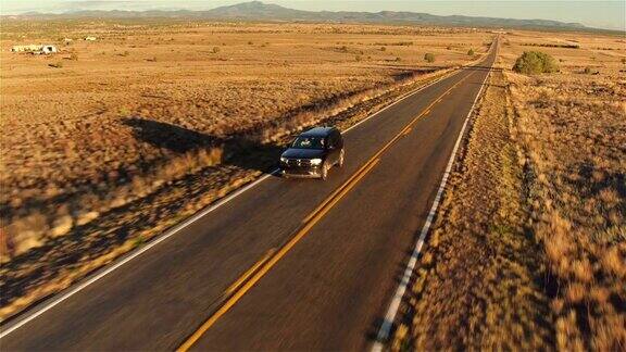 图片:日落时分一辆SUV行驶在空旷的乡村道路上