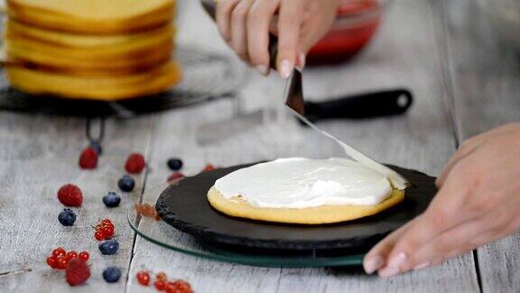 糖果师傅在蛋糕上涂抹奶油用浆果做馅的蛋糕的制作过程