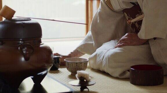 在日本传统茶道上主人搅拌茶并奉上碗