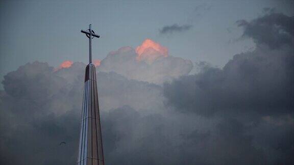 高高的十字架从教堂的屋顶外飞过暴风雨的天空