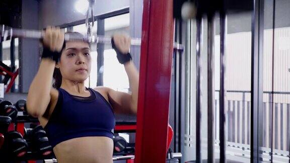 年轻的健身女士在健身房用负重器械做运动健身训练理念