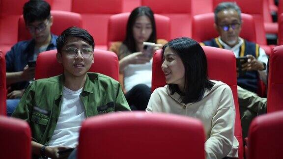 亚洲的中国年轻夫妇在电影院等电影的时候享受着彼此的陪伴