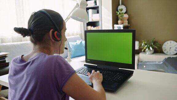 妇女在家里使用带有绿色屏幕的笔记本电脑