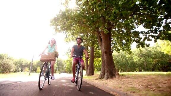 一对年轻夫妇在慢镜头中愉快地一起骑自行车