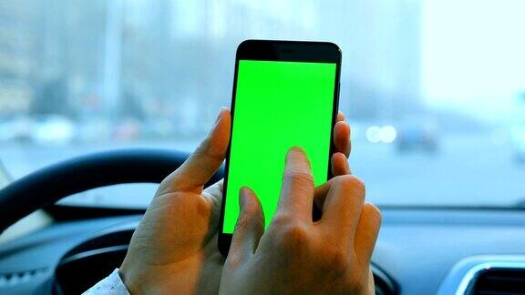 男人在车里用智能手机绿色屏幕