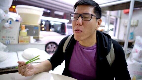在香港一名男子正在吃蘸着传统酱汁的米粉卷