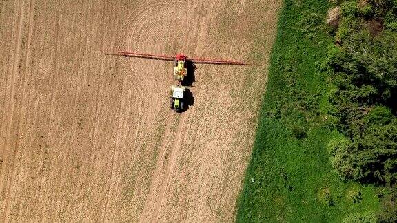 农用拖拉机在早春喷洒田间鸟瞰图