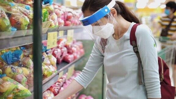 新冠肺炎后的新常态亚洲妇女戴口罩、口罩在超市购物