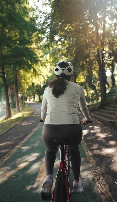 年轻女性在公园骑自行车