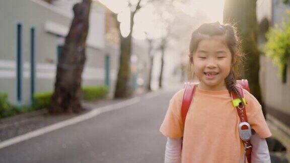 小日本女学生在住宅区樱花树下步行上学