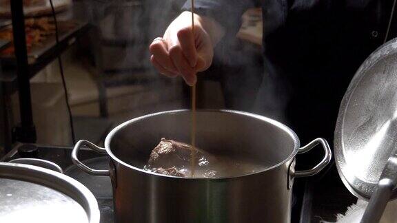 餐馆厨房里金属锅里沸腾的肉汤高清