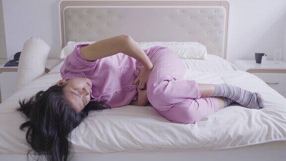 一位妇女因胃痛躺在床上