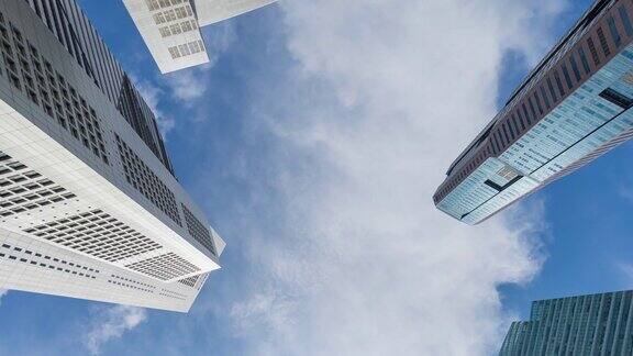 低角度的现代建筑与移动的云和蓝天直接在下面拍摄的时间流逝视频