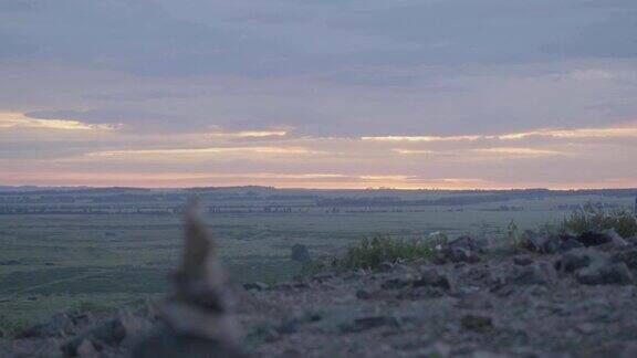 卵石塔禅意与平衡一堆鹅卵石映着天空在田野和清晨天空的背景上有一座石塔