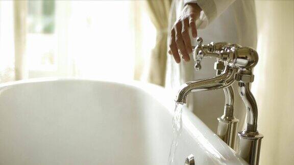 一个女人关掉浴室里浴缸的水龙头