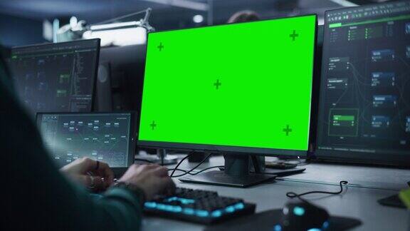 近距离的软件开发人员工作在桌面计算机与绿色屏幕模拟显示专业键盘打字编码和实现一个新的技术特点静态的画面