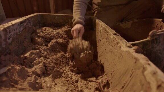 将粘土混合物舀出放入灰泥桶