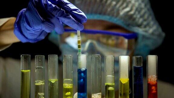 科学家在黑暗的实验室里用蓝色液体在试管中测量酸性水平