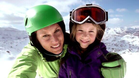 SLOMO母亲和女儿在滑雪坡上的视频自拍