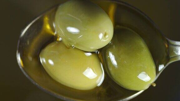 橄榄油滴在勺子里的橄榄上
