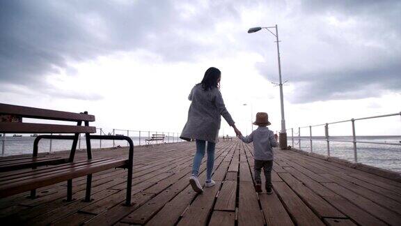 母亲和儿子在木栈桥上玩耍