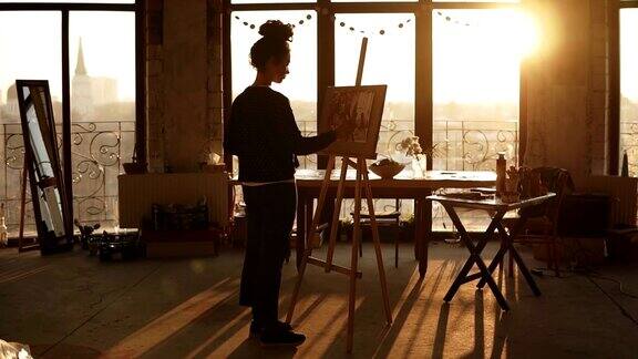 女性艺术家在艺术工作室里的画架上画画